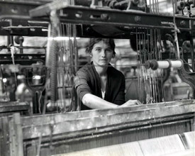 1933 photograph of woman weaving at industrial loom
